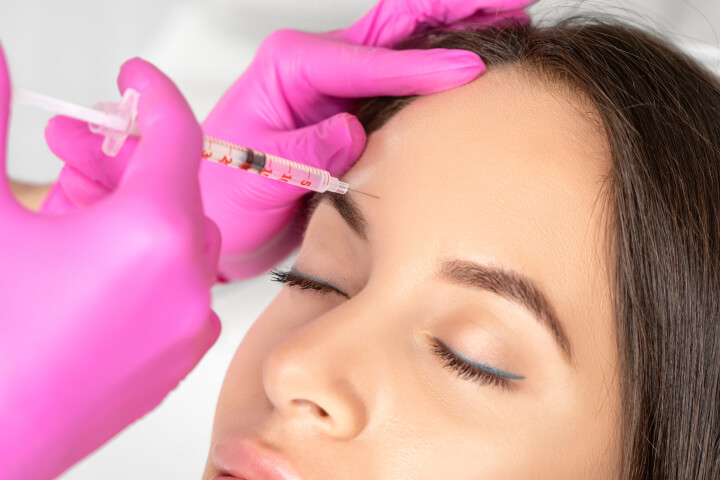woman receiving botox injection in her forehead
