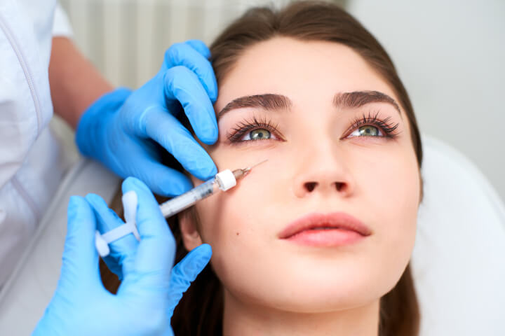woman receiving a dermal filler injection in her face