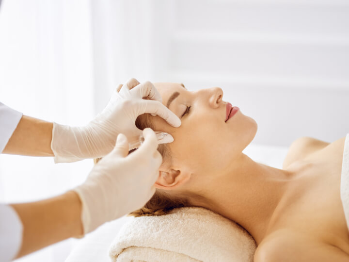 woman receiving an injection of dermal fillers by a professional medical doctor