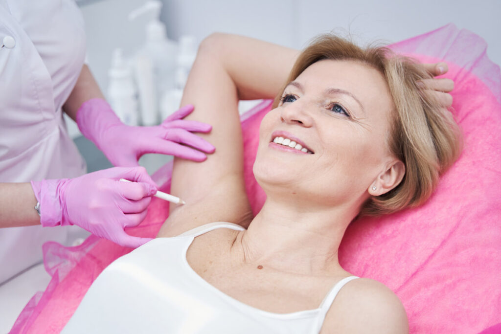 professional cosmetologist drawing lines for botox procedure for underarms